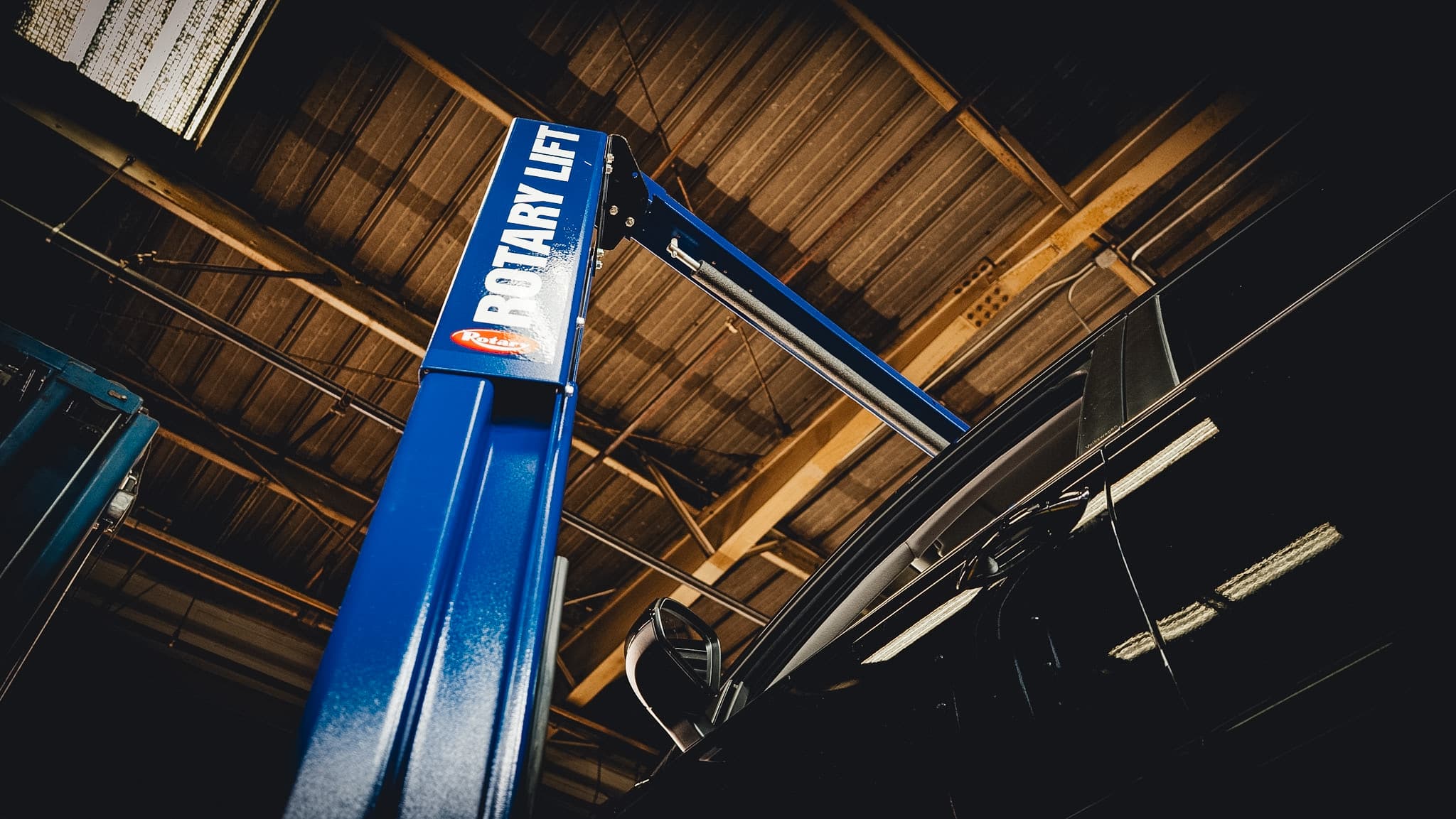 Technician checking under-hood components during scheduled maintenance.